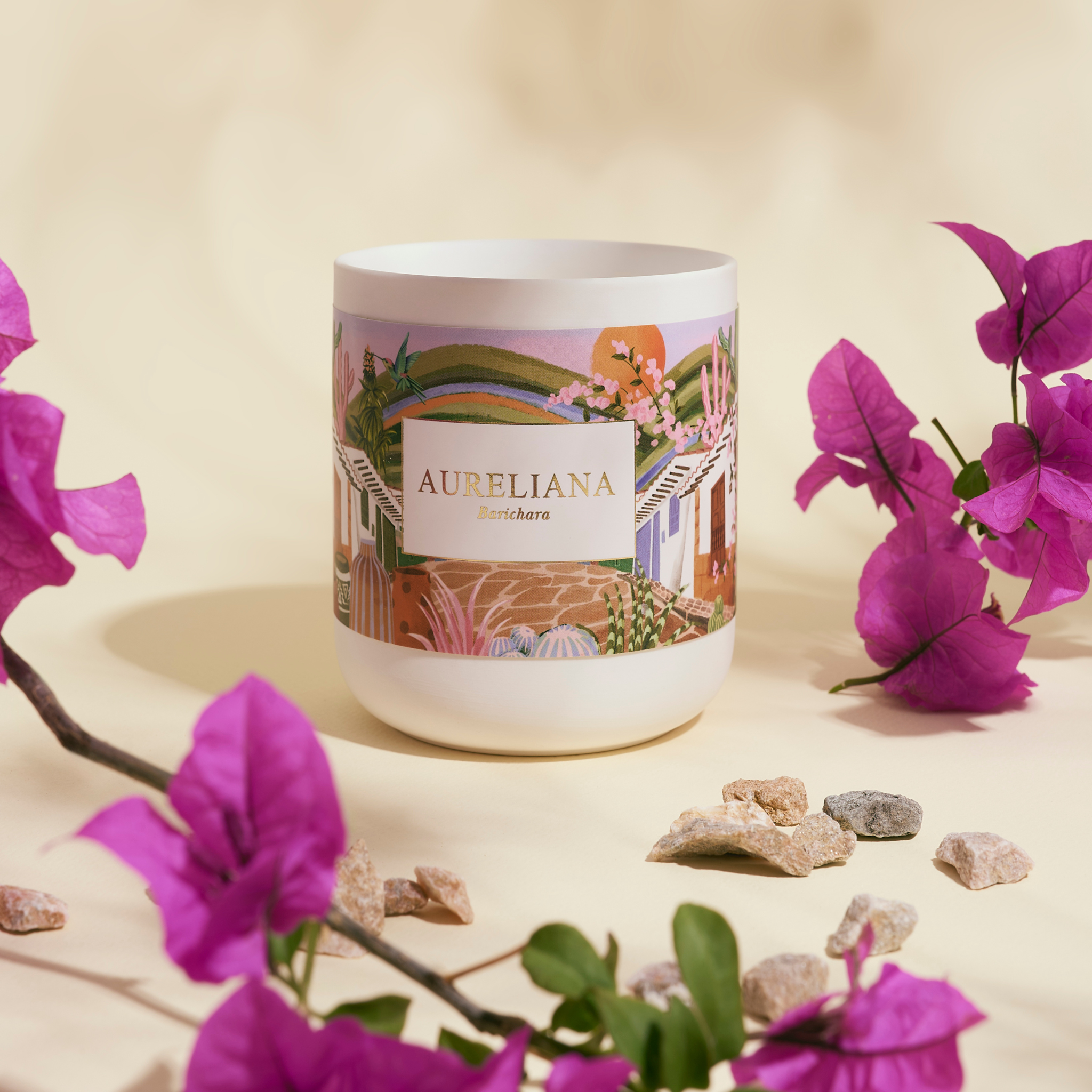 Candle labeled 'Aureliana' with purple flowers and stones on a beige background