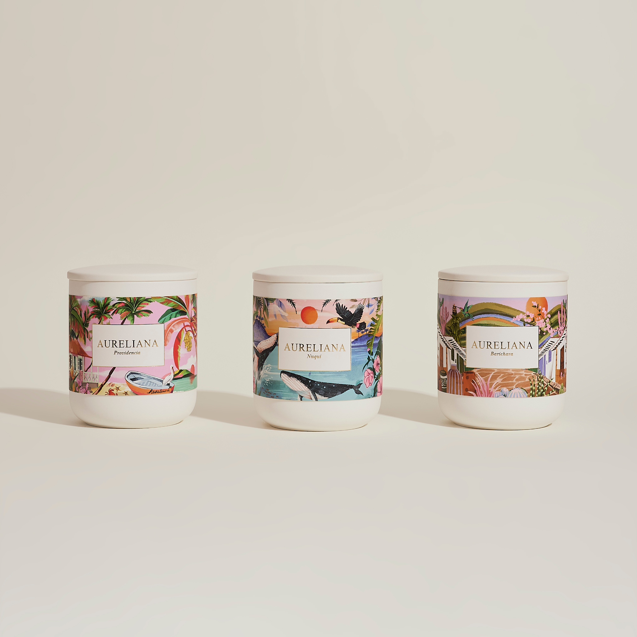 Three Aureliana candles with decorative labels on a light background